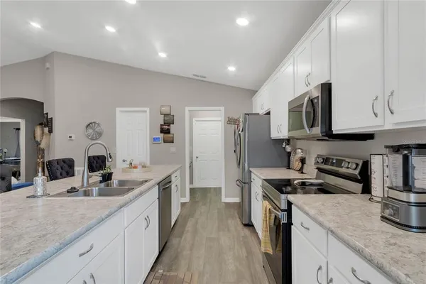 a kitchen with stainless steel appliances granite countertop a sink stove and refrigerator