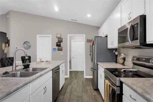 a kitchen with stainless steel appliances granite countertop a sink stove microwave and refrigerator