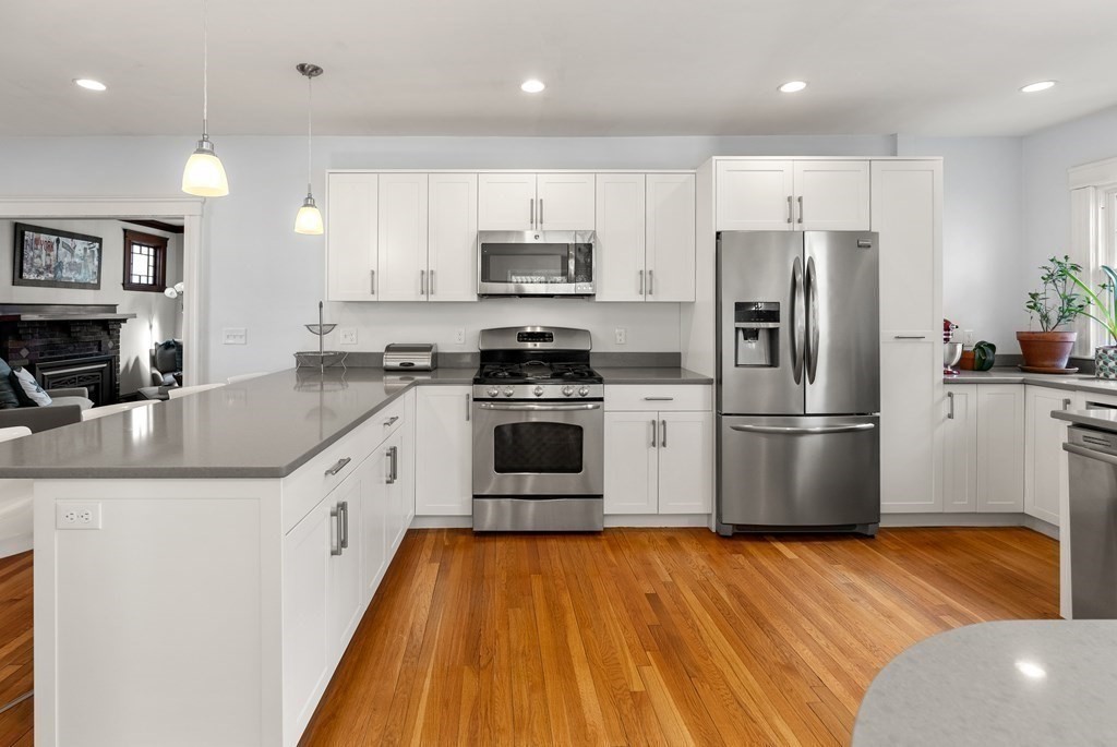 46 Downing Road Lexington, MA 02421 - Photo 10 of 29 a kitchen with granite countertop a refrigerator a stove top oven a sink and dishwasher with wooden floor