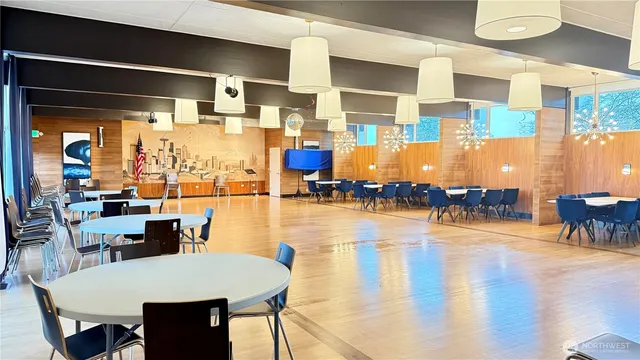 a dining room with wooden floor table and chairs