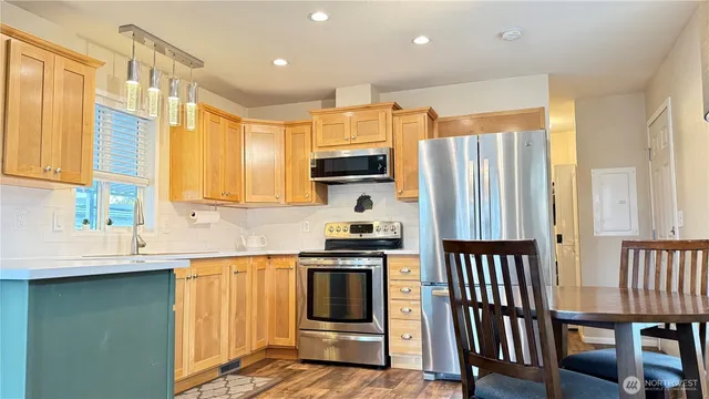 a kitchen with stainless steel appliances granite countertop a stove a sink and a refrigerator