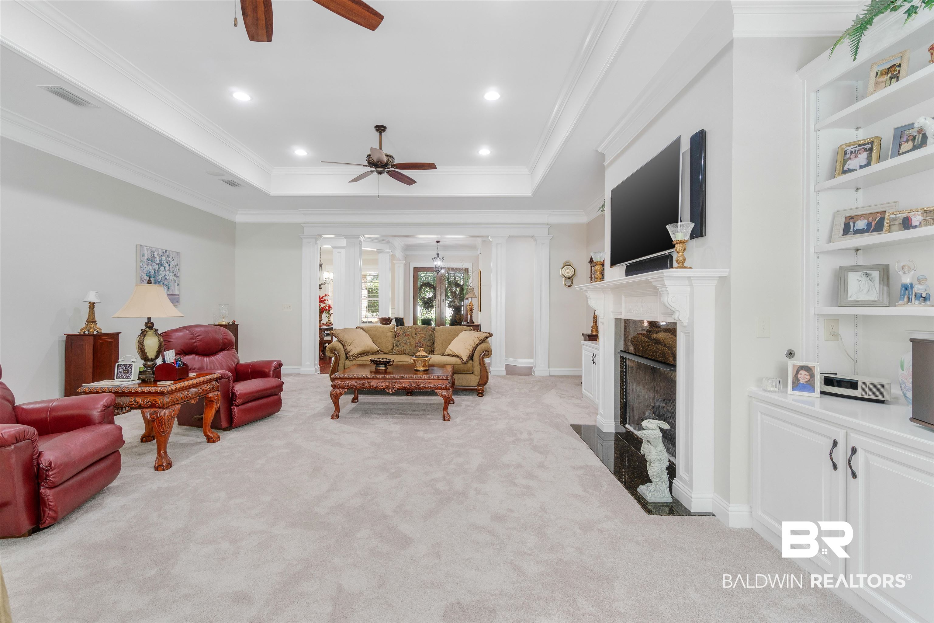 11281 Redfern Road Daphne, AL 36526 - Photo 13 of 80 Living room with crown molding, light carpet, a tray ceiling, a premium fireplace, and ceiling fan
