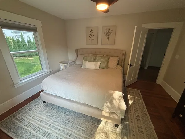 a large bed sitting in a bedroom next to a window