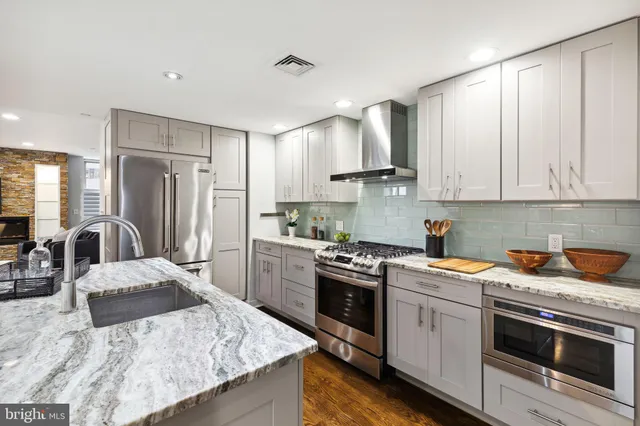 a kitchen with stainless steel appliances granite countertop a sink stove and refrigerator