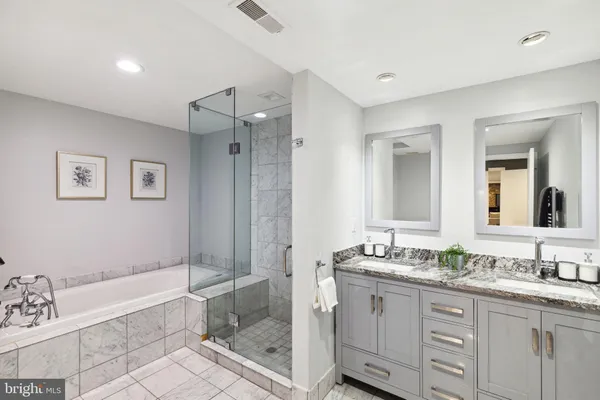 a bathroom with a granite countertop tub sink shower and mirror