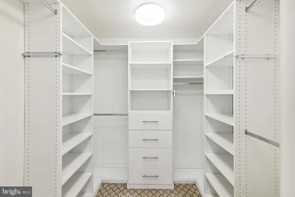 a view of walk in closet with empty racks