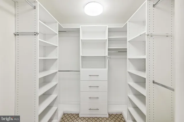 a view of walk in closet with empty racks