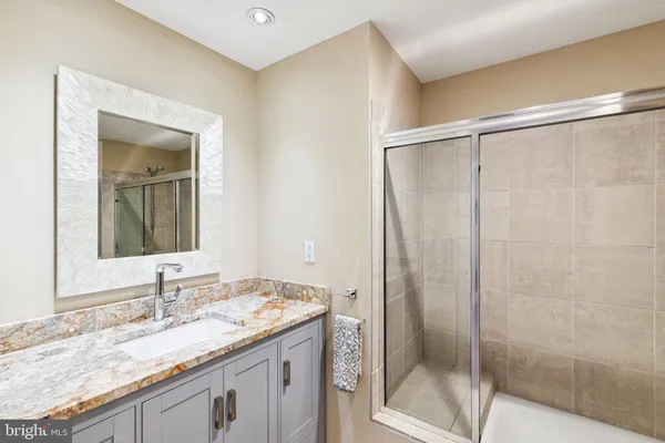 a bathroom with a granite countertop sink and a mirror