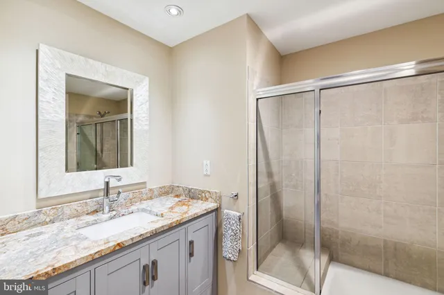 a bathroom with a granite countertop sink and a mirror
