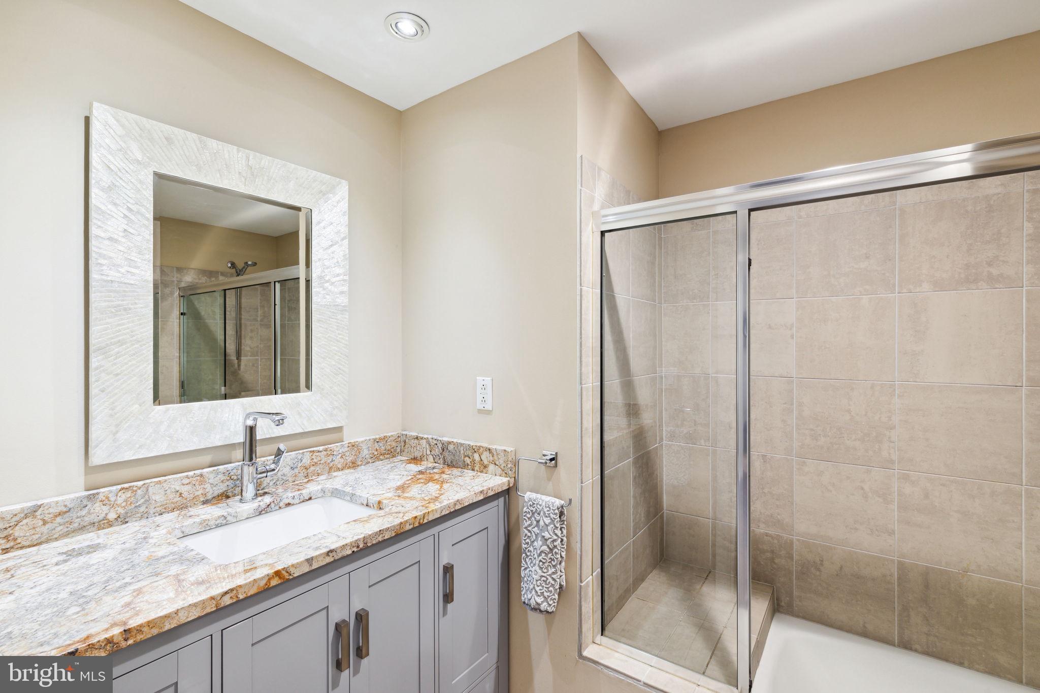 1737 Chestnut Street, Unit 501 Philadelphia, PA 19103 - Photo 23 of 27 a bathroom with a granite countertop sink and a mirror
