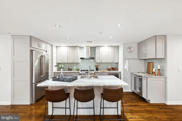 a kitchen with stainless steel appliances granite countertop a table and chairs in it