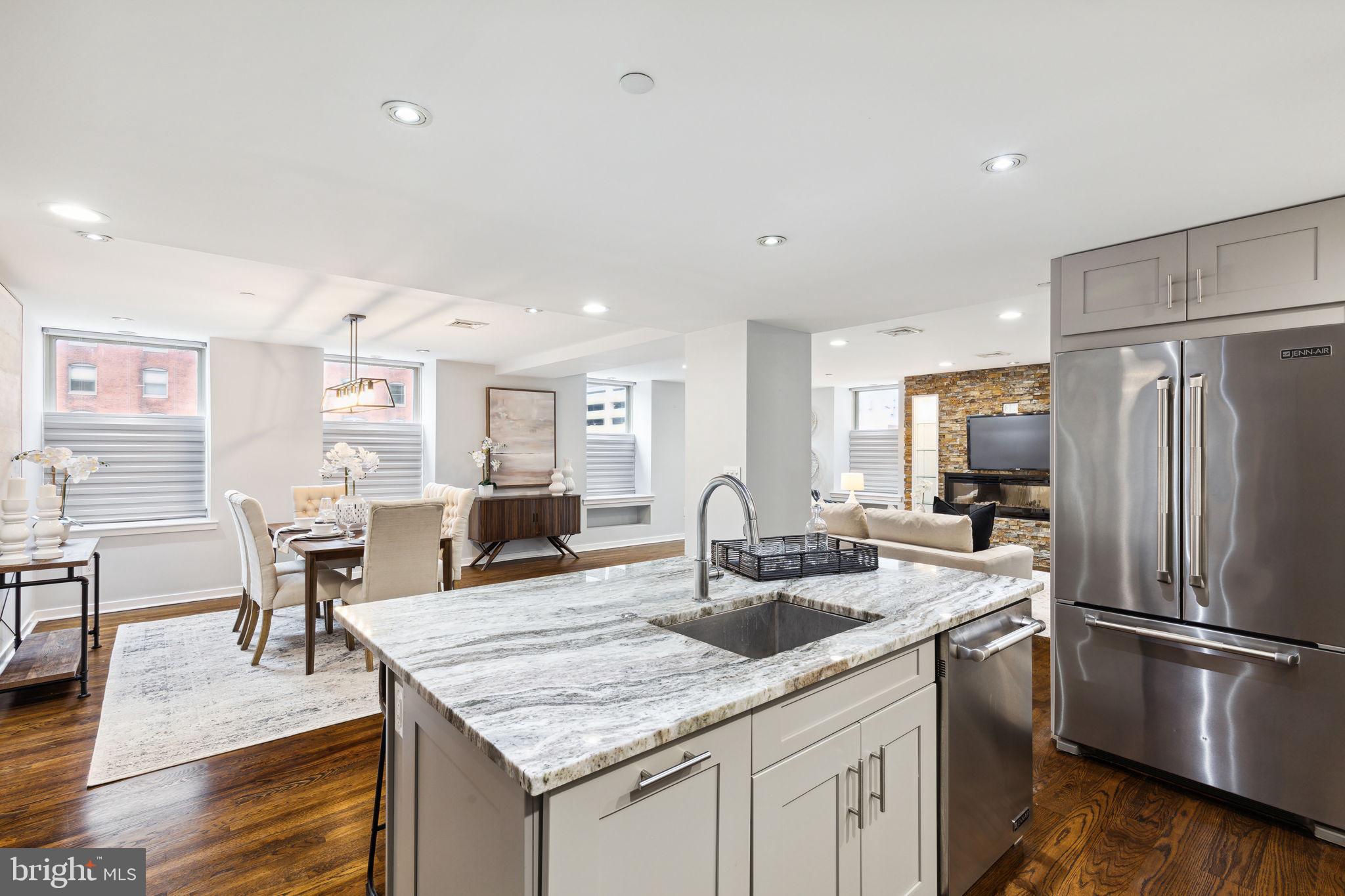 1737 Chestnut Street, Unit 501 Philadelphia, PA 19103 - Photo 10 of 27 a kitchen with stainless steel appliances granite countertop a sink refrigerator and chairs