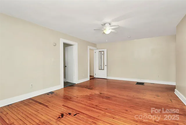 a view of an empty room with wooden floor