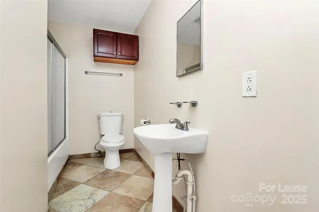 a bathroom with a sink toilet and a mirror