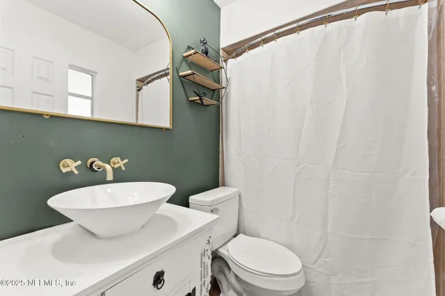 a bathroom with a toilet a sink and a mirror