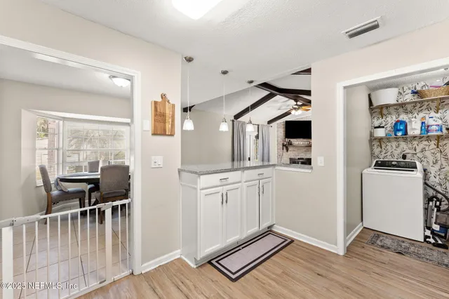 a kitchen with stainless steel appliances granite countertop a refrigerator a stove and a sink with wooden floor