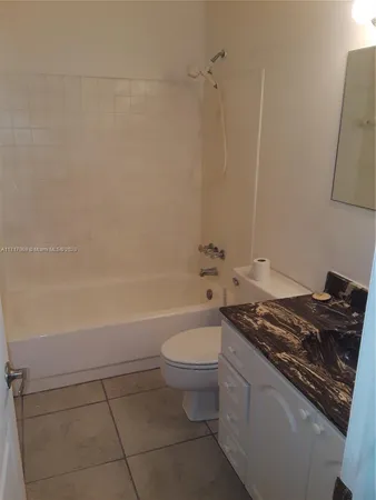 a bathroom with a granite countertop toilet a sink and bathtub