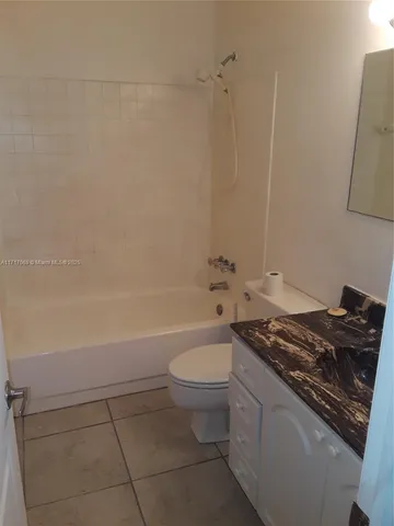 a bathroom with a granite countertop toilet a sink and bathtub
