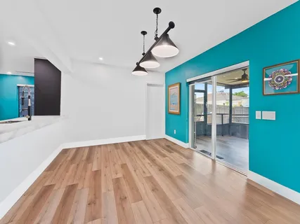 a view of an empty room with window and wooden floor