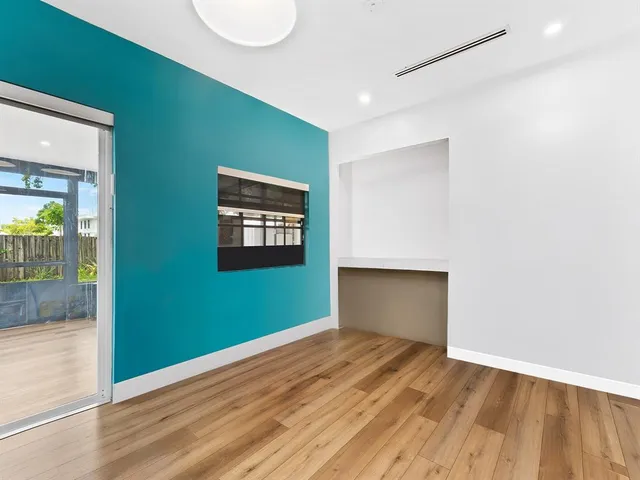 an empty room with wooden floor and a window