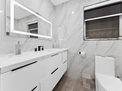 a bathroom with a sink a toilet and mirror