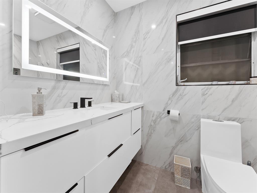 4411 Thomas Street Hollywood, FL 33021 - Photo 14 of 21 a bathroom with a sink a toilet and mirror