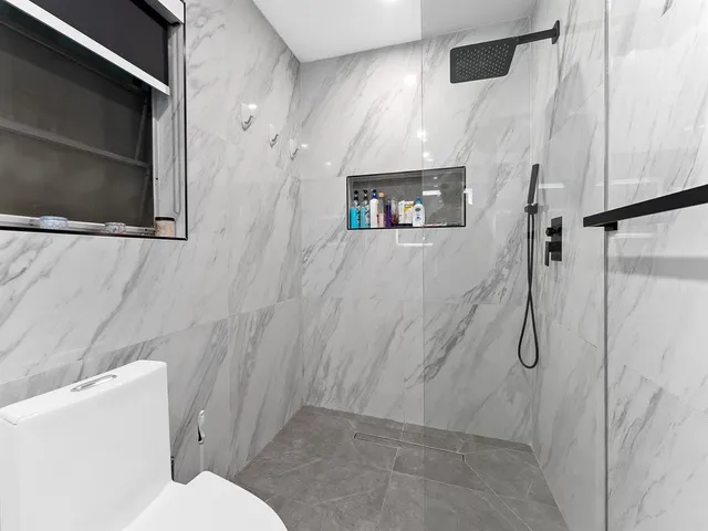 a bathroom with a toilet sink and shower