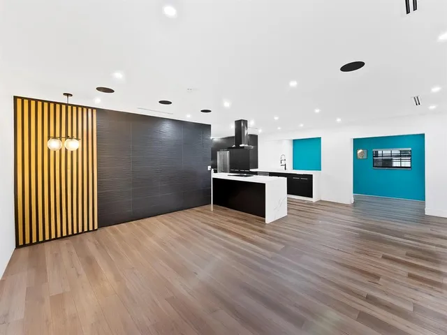 a view of kitchen with stainless steel appliances granite countertop wooden floor and window
