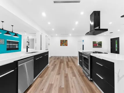 a large kitchen with stainless steel appliances granite countertop a stove and a sink