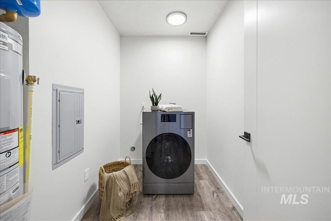 4184 East Haystack Street, Unit 103 Boise, ID 83716 - Photo 13 of 27 Dedicated laundry area featuring a front-load washing machine, wood-finish flooring, and white walls