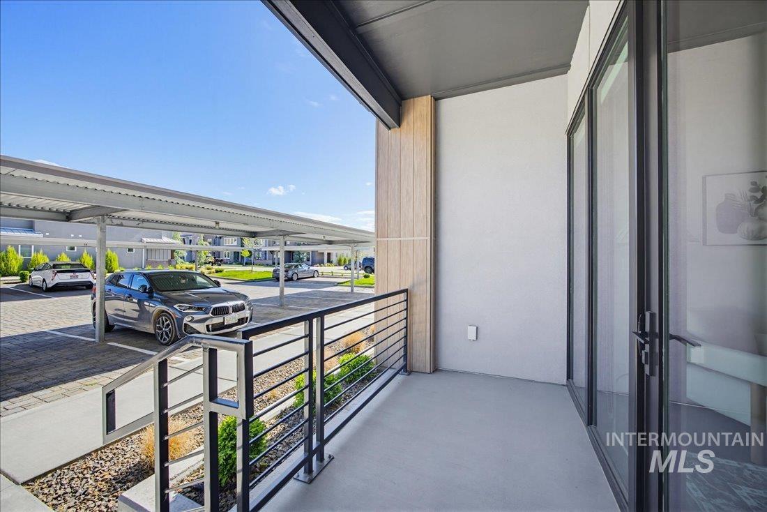 4184 East Haystack Street, Unit 103 Boise, ID 83716 - Photo 14 of 27 Private balcony featuring a concrete floor, dark metal railings, and a wood-finish accent wall