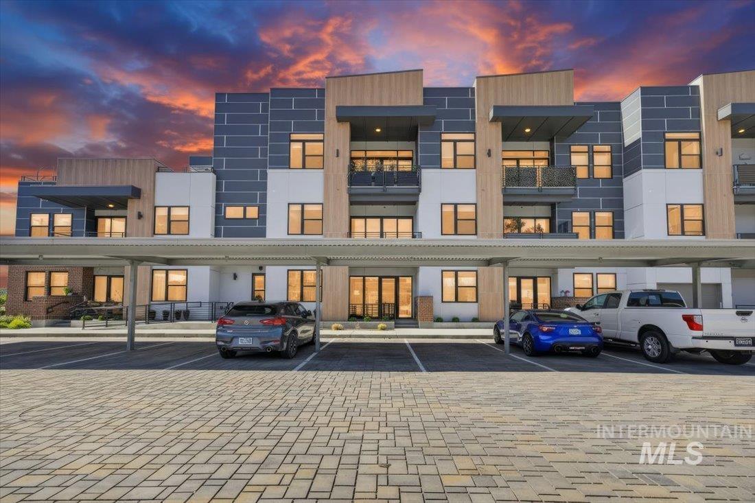 4184 East Haystack Street, Unit 103 Boise, ID 83716 - Photo 24 of 27 Modern multi-story building featuring varied paneling, expansive windows, balconies with metal railings, and covered parking