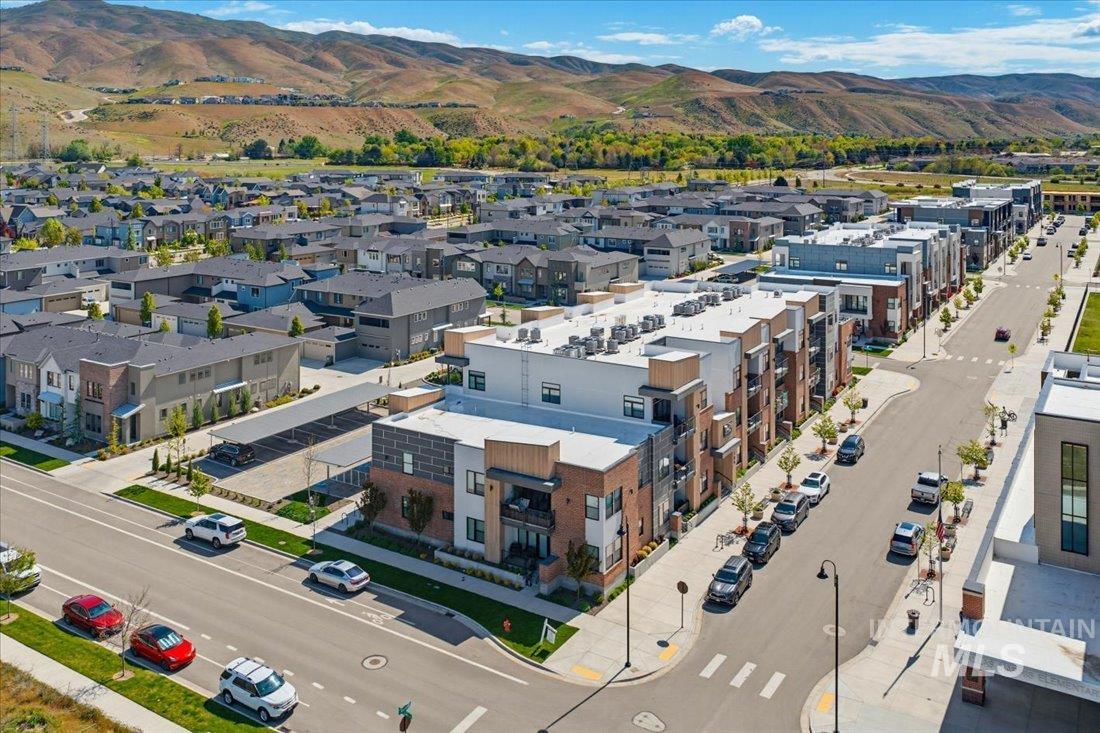 4184 East Haystack Street, Unit 103 Boise, ID 83716 - Photo 26 of 27 Modern multi-story residential building featuring balconies, brick and panel siding, and a flat roof