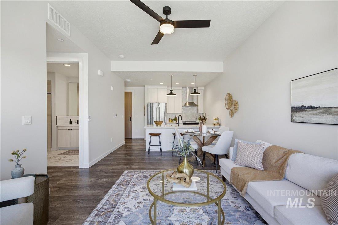 4184 East Haystack Street, Unit 103 Boise, ID 83716 - Photo 3 of 27 Open-concept living space featuring wood-finish flooring, a modern black ceiling fan, recessed lighting, and a kitchen with white cabinetry and stainless steel appliances