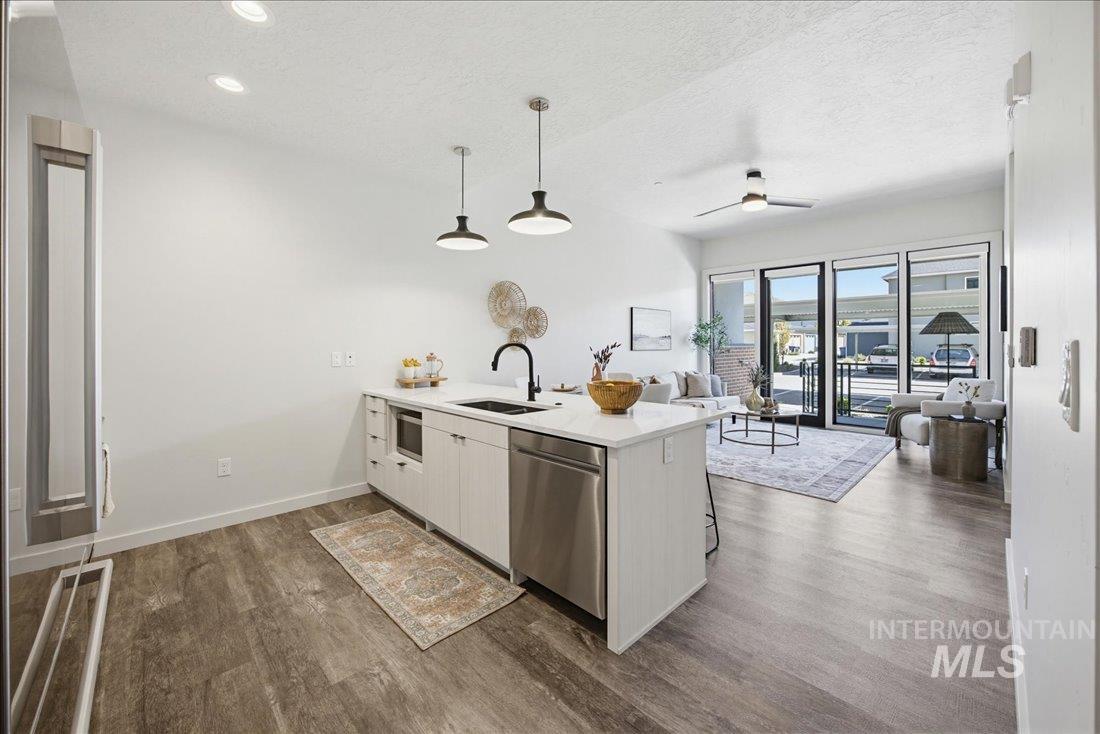 4184 East Haystack Street, Unit 103 Boise, ID 83716 - Photo 5 of 27 Modern open-concept living space featuring wood-finish flooring, recessed ceiling lighting, and a kitchen island with pendant lighting