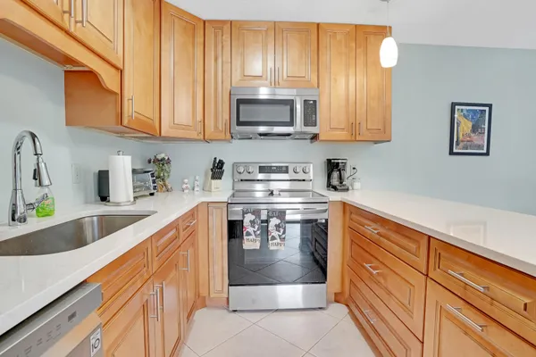 a kitchen with stainless steel appliances granite countertop a sink stove and microwave