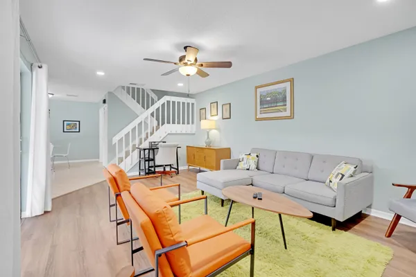 a living room with furniture and a wooden floor