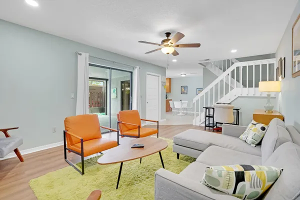a living room with furniture and a ceiling fan