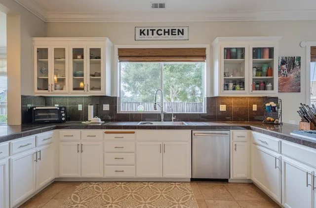 a kitchen with granite countertop a sink cabinets and dining table