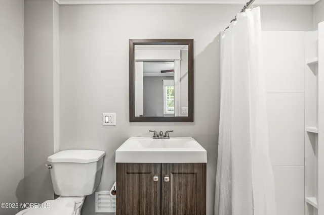 a bathroom with a sink a toilet and a mirror