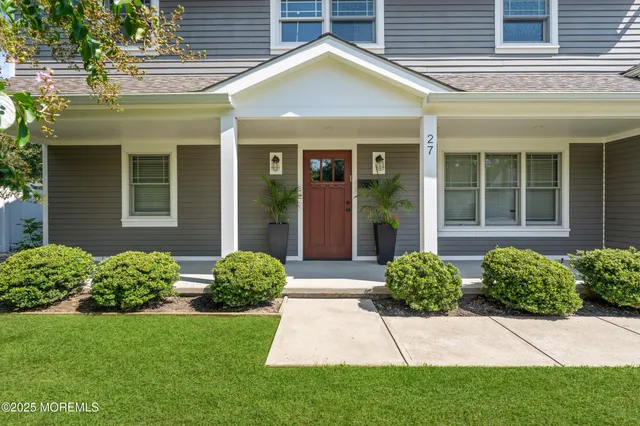 a view of a house with brick walls and a yard with plants