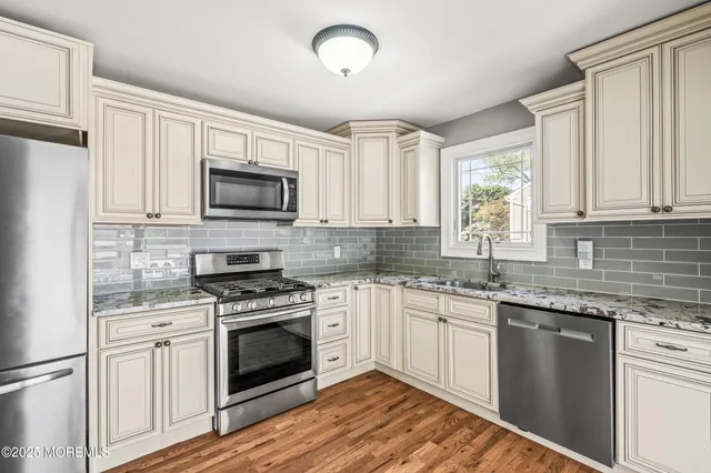 a kitchen with granite countertop a stove top oven sink and cabinets