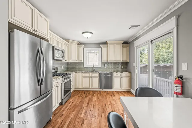 a kitchen with stainless steel appliances a refrigerator sink and cabinets