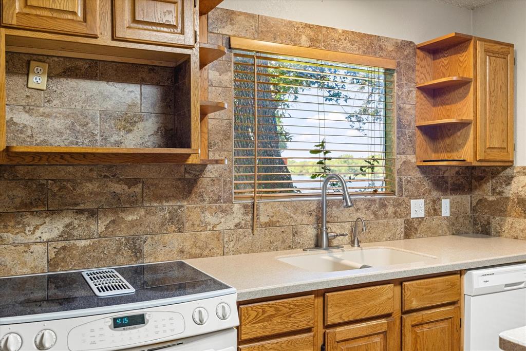 246 Comanche Trail Weatherford, TX 76087 - Photo 14 of 37 a kitchen with stainless steel appliances granite countertop a sink a stove and a window