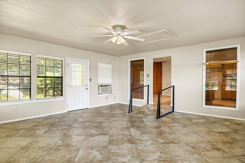 246 Comanche Trail Weatherford, TX 76087 - Photo 20 of 37 an empty room with chandelier fan and windows