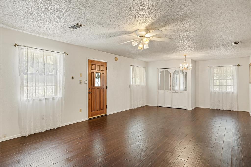 246 Comanche Trail Weatherford, TX 76087 - Photo 5 of 37 a view of an empty room with wooden floor and window