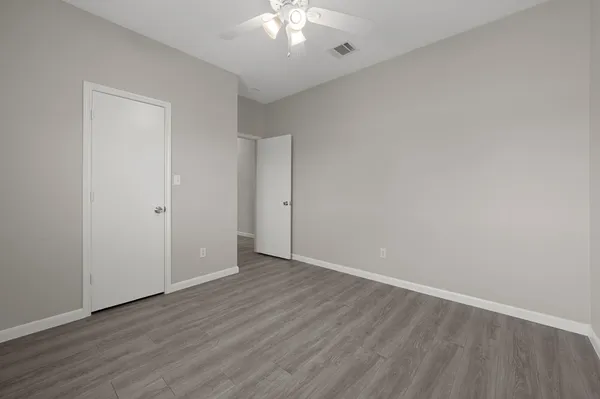 a view of an empty room with wooden floor