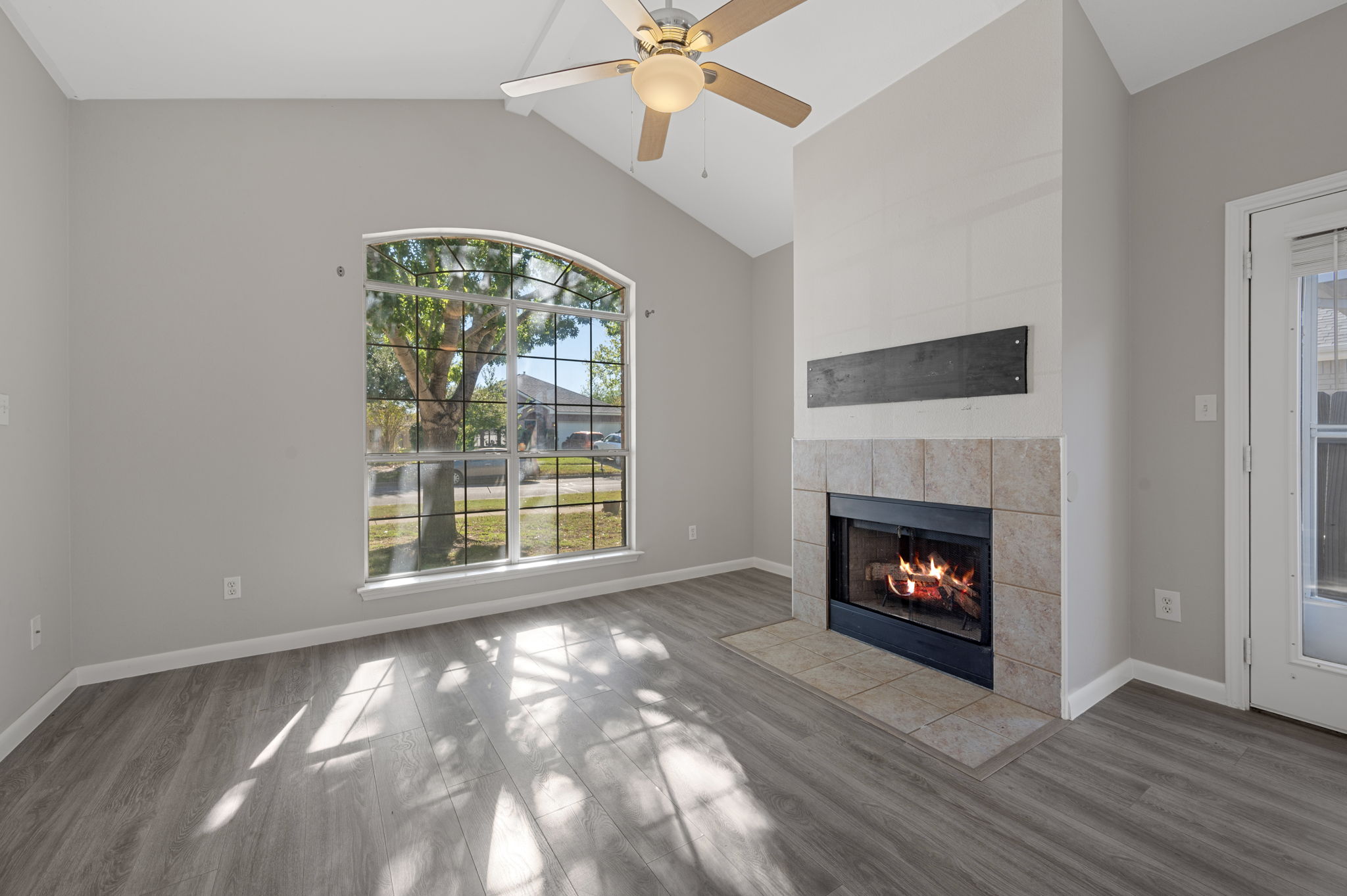 106 Shenandoah Trail Elgin, TX 78621 - Photo 7 of 26 a view of an empty room with wooden floor fireplace and a window