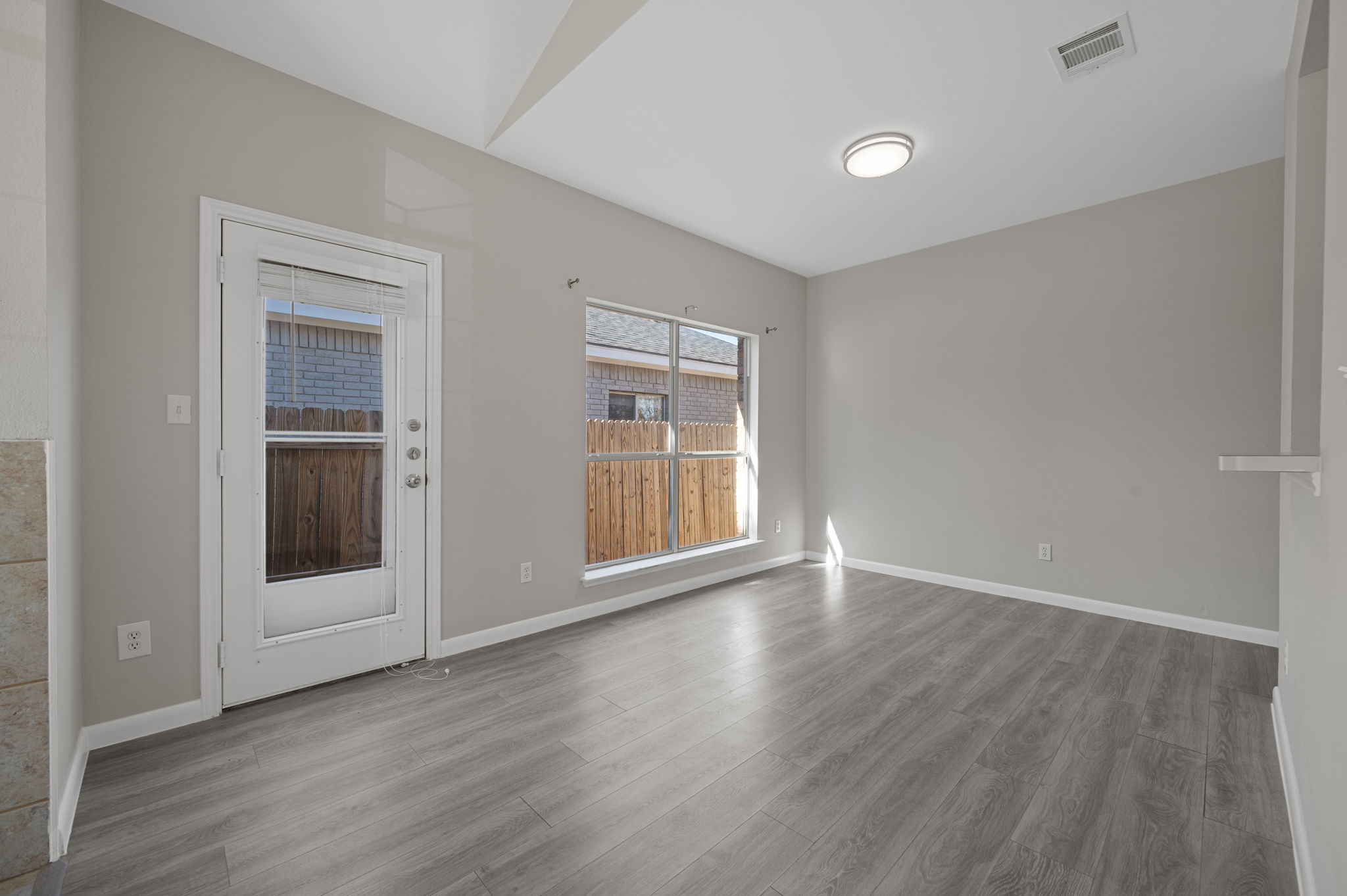 106 Shenandoah Trail Elgin, TX 78621 - Photo 8 of 26 a view of an empty room with wooden floor and a window