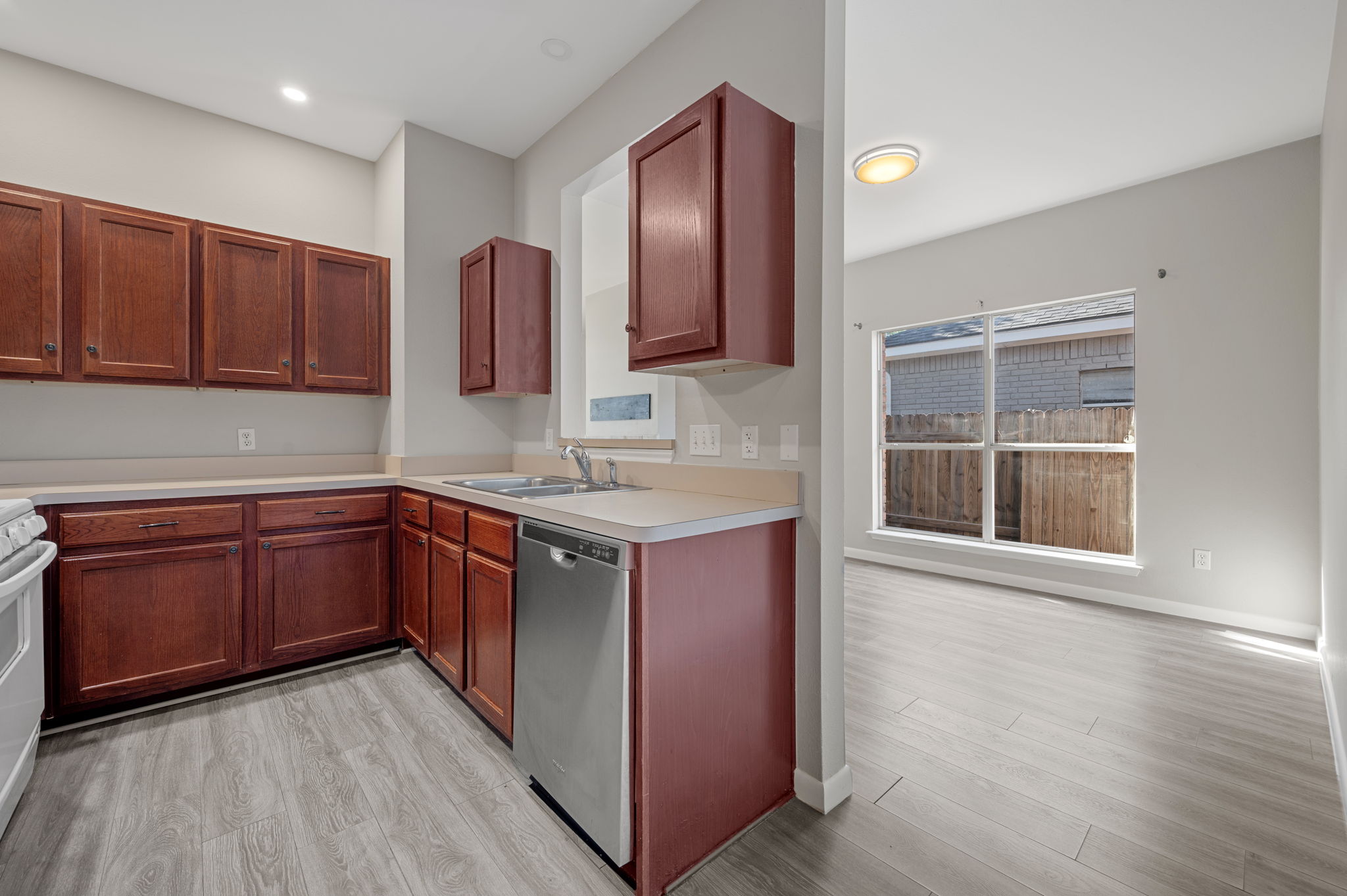 106 Shenandoah Trail Elgin, TX 78621 - Photo 10 of 26 a kitchen with stainless steel appliances granite countertop wooden cabinets a sink and dishwasher with wooden floor